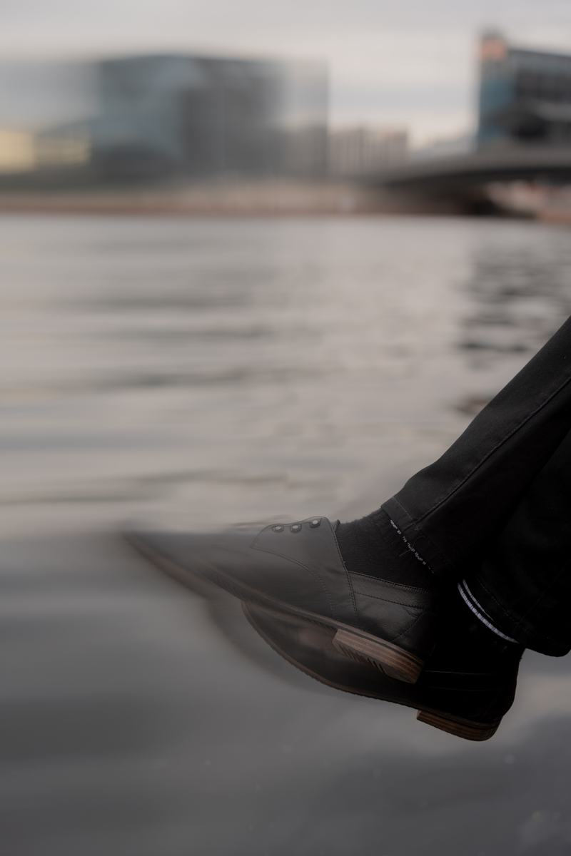 Ein Schuh schwebt über dem Wasser der Spree, kurz vor dem Schritt