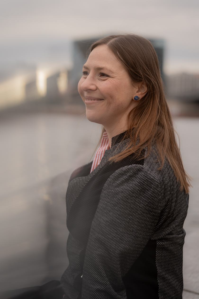 Maria lacht am Fluss in Berlin, im Profil